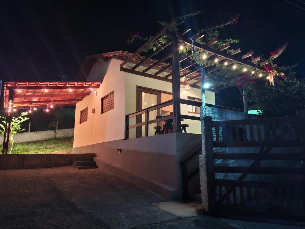 a house with a pergola at night with lights at Chalé Mandacaru in Monte das Gameleiras