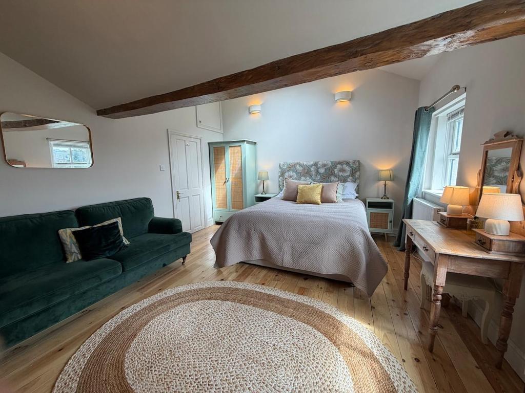 a bedroom with a bed and a green couch at Charming Town House Central Margate in Margate