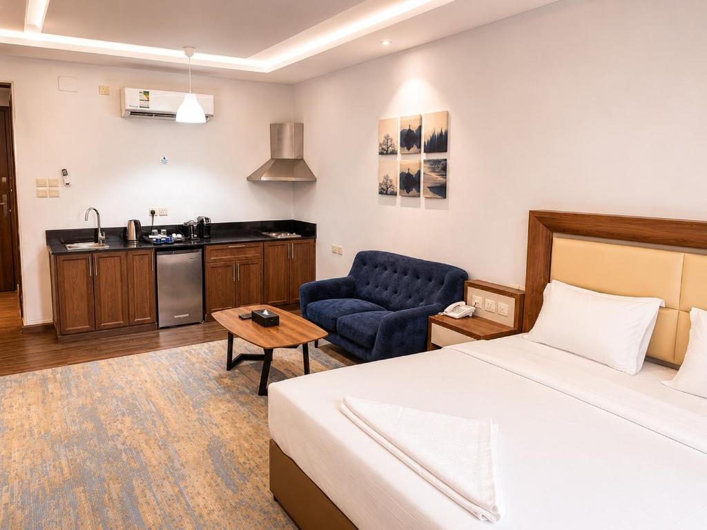 a hotel room with a bed and a kitchen at شركة نيلوفر بلس للخدمات الفندقيه in Abha