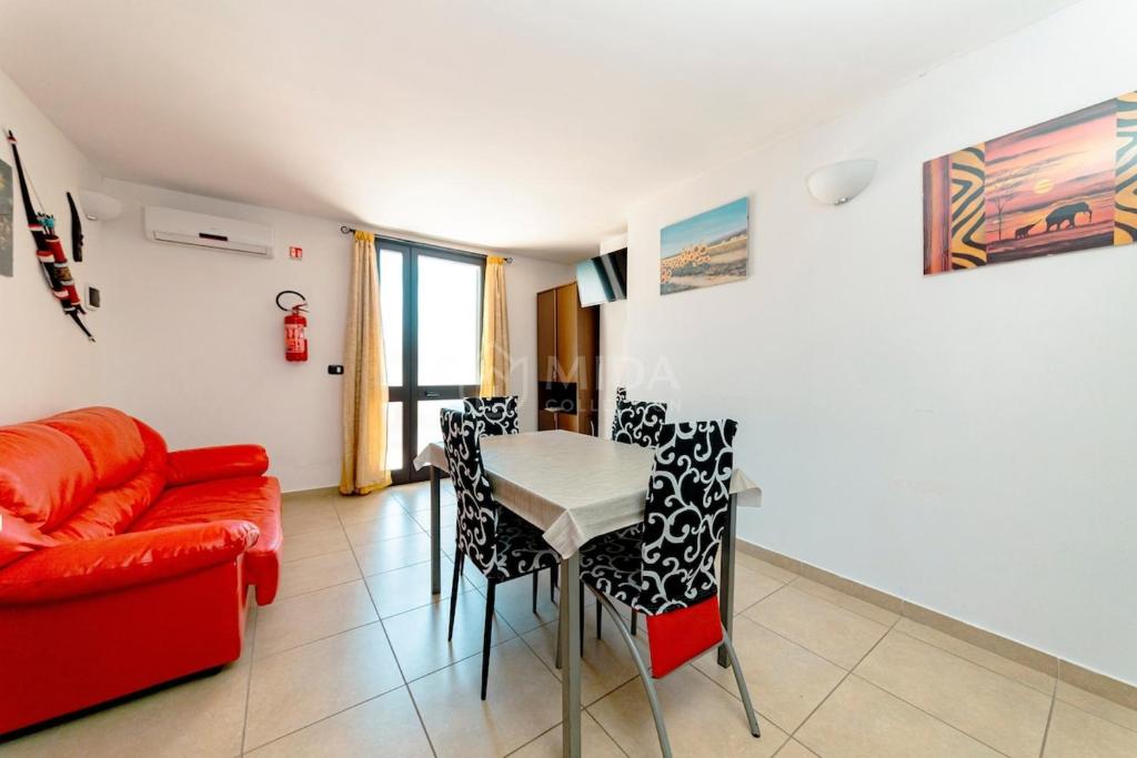 a living room with a red couch and a table at Arabic Sea Apartments in Porto Cesareo