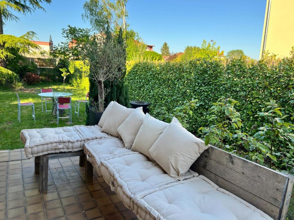 een bank met kussens op een terras bij House with garden in Pérouges