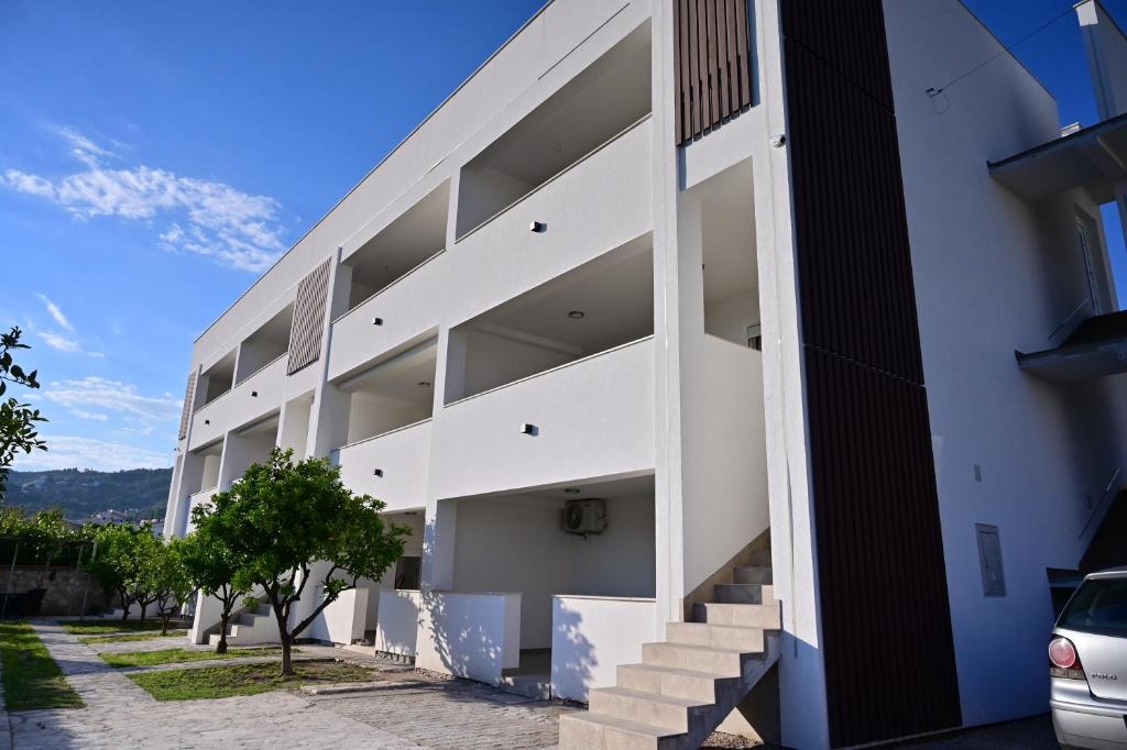 a white building with stairs on the side at Apartments Gajić with Private Free Parking - New & Modern in Bar