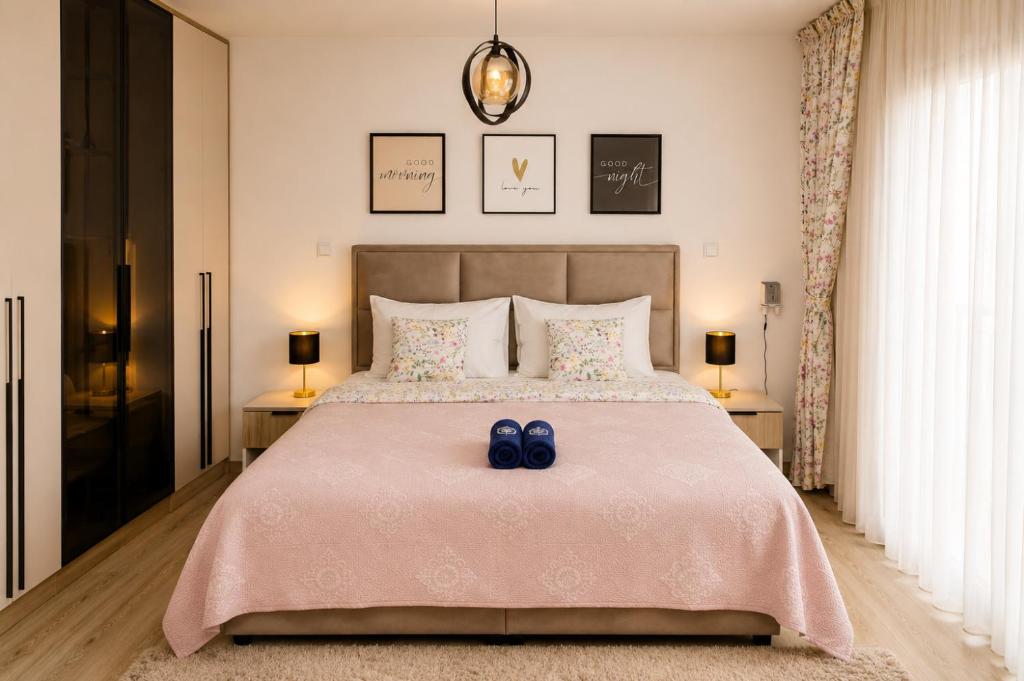 a bedroom with a bed with two blue shoes on it at VIP Apartman Friendly Home in Tuzla