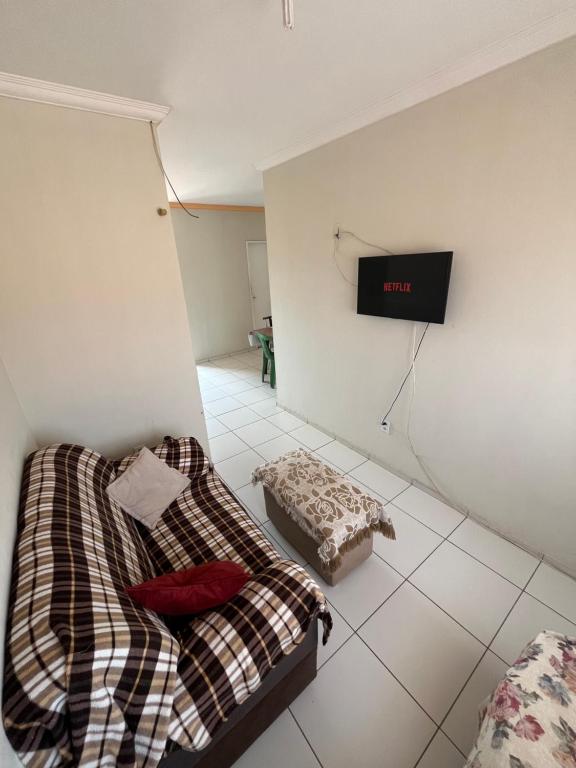 a room with two beds and a tv on the wall at Casa no pavimento superior in São Luís