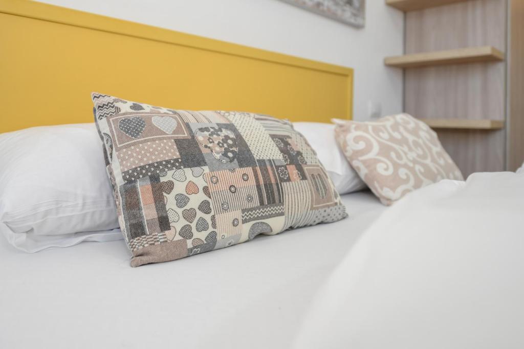 a bed with three pillows on top of it at Baldo View Studio in Toscolano Maderno