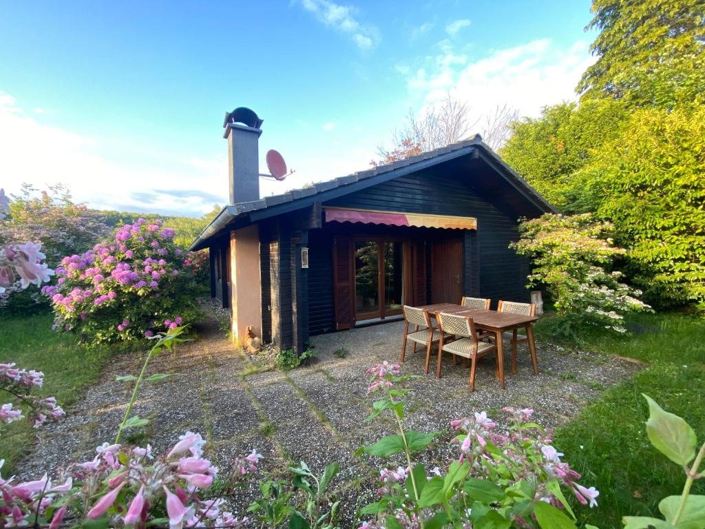 a small cabin with a table and chairs in a garden at Gemütliche Hütte im Grünen in Dammbach