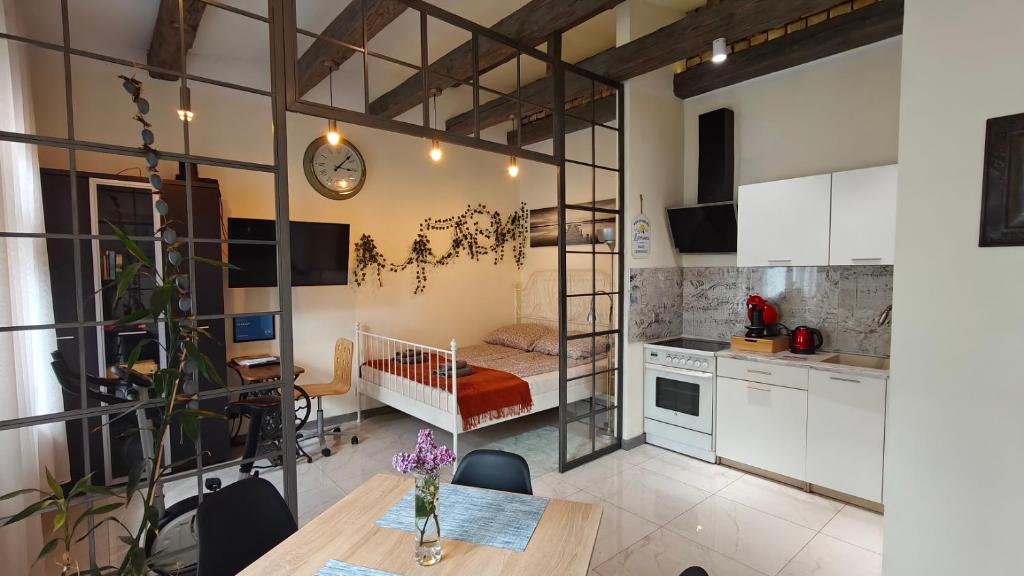 a kitchen with a table and a dining room at La La Loft in Bytom