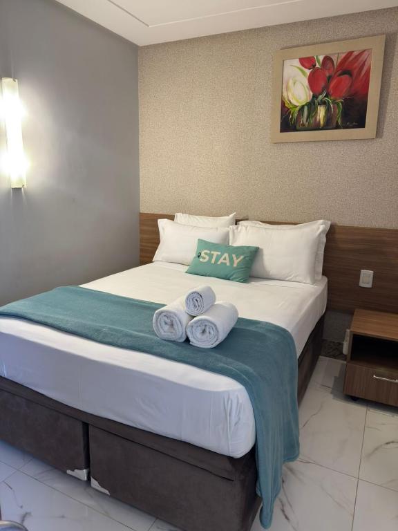 a hotel room with a bed with towels on it at STAY Sun Square in Goiânia