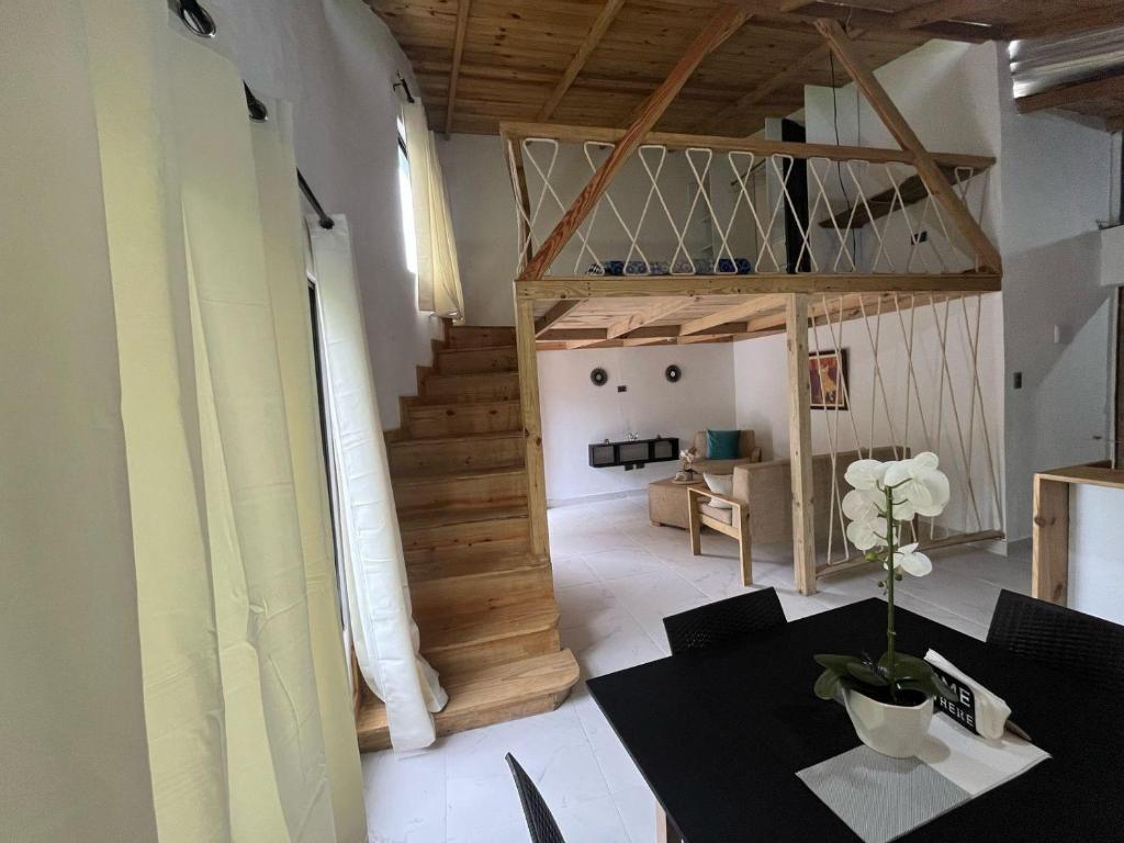 a living room with a table and a staircase at Almonte House in Puerto Plata
