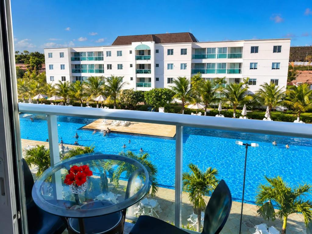 a view of the pool from the balcony of a resort at Lindo apartamento em Muro Alto, Porto de Galinhas, Vista para as piscinas, 3 qtos e sala climatizados, Acomoda até 8 pessoas in Ipojuca