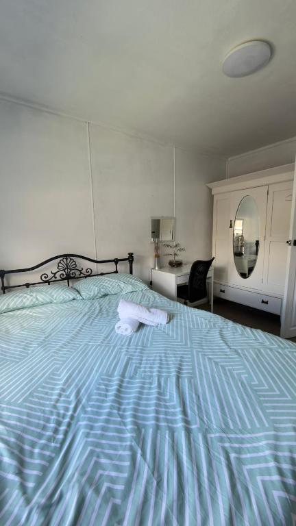 ein großes Bett in einem Schlafzimmer mit einer blauen Bettdecke in der Unterkunft Private Double Room Shared Bathroom in Warrane