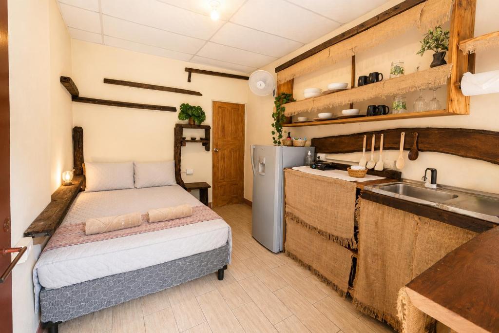 a small kitchen with a bed and a sink at Casa Xuchi in Juayúa