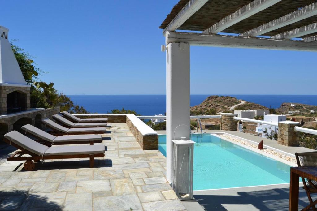 a pool with lounge chairs and a view of the ocean at Villa Giulia, Seaview Villa near Chora in Ios Chora