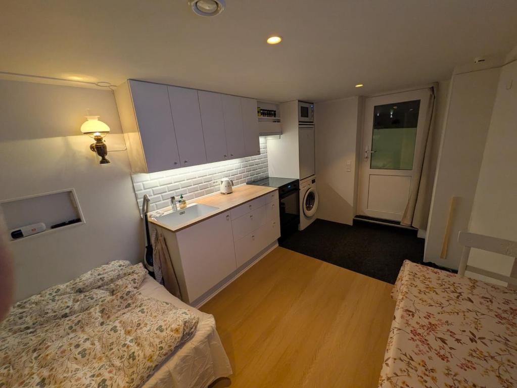 a room with two beds and a kitchen with a sink at Elf's Cottage in Vatnsoyrar