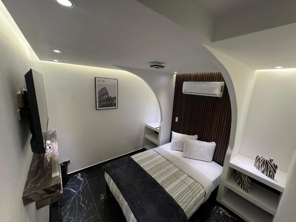 a small room with a bed and a tv at Loft Rome Nacosari in Aguascalientes