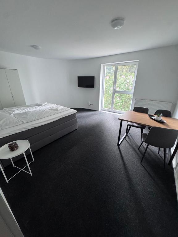 a bedroom with a bed and a table and chairs at Ferienapartments Sternen WOHN 7 in Baiersbronn