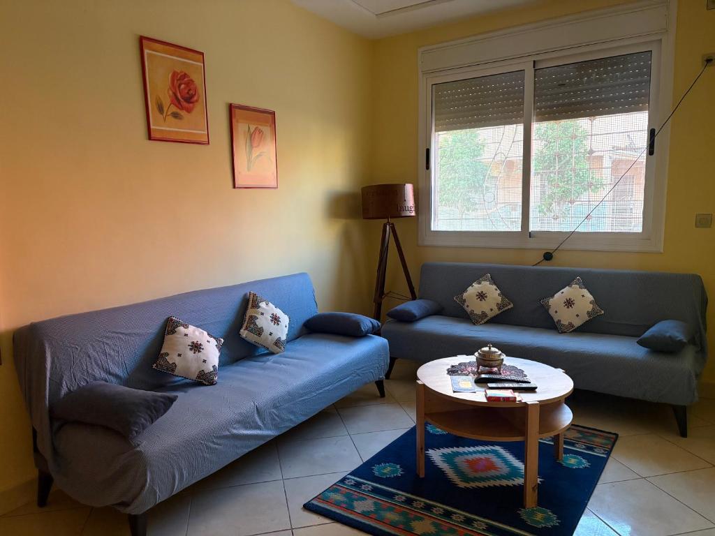 a living room with a blue couch and a table at saidia 700 m de la plage in Saïdia