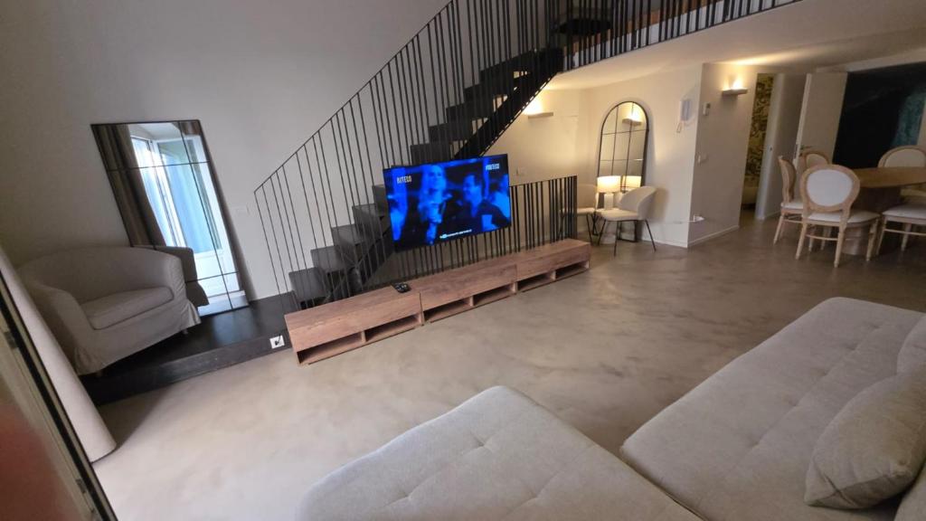 a living room with a flat screen tv on a couch at La Pietra - Bari Vecchia, Vista Mare in Bari