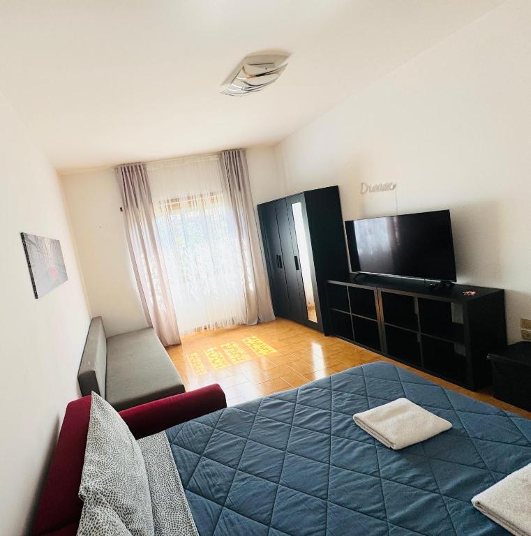 a living room with a blue bed and a television at Nido Urbano Roma in Rome