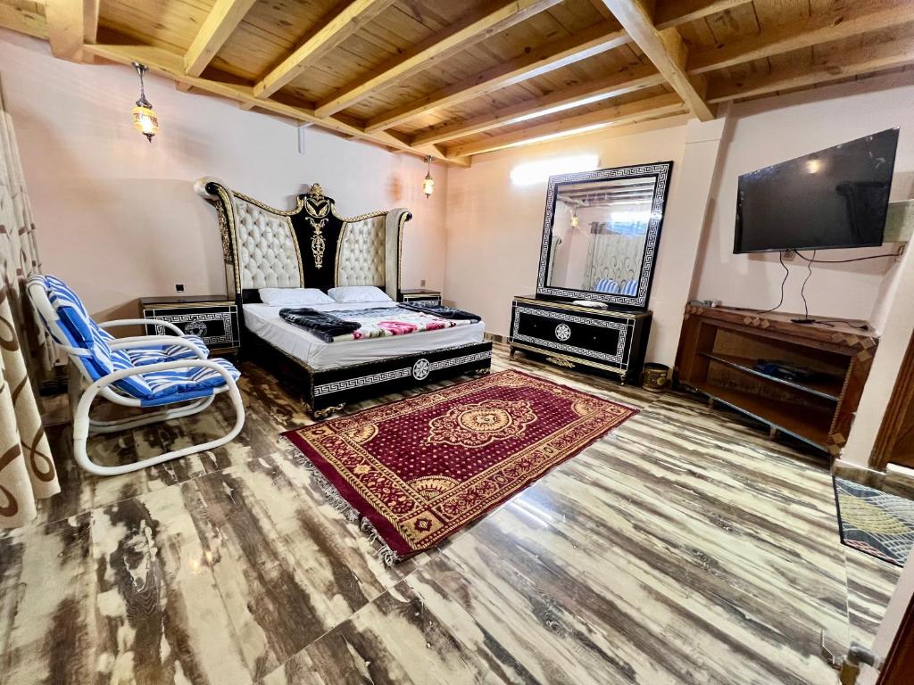a bedroom with a bed and a television and a chair at The Valley View Pent House in Murree