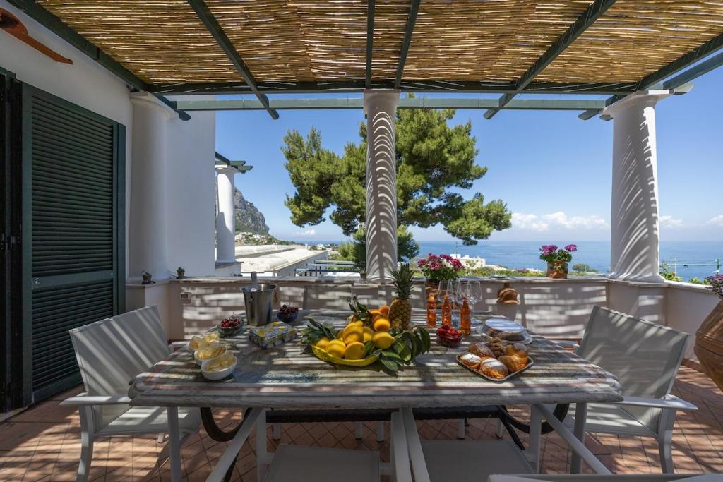 a table with fruits and vegetables on a patio at Villa Preziosa - Panoramic Sea View in Capri