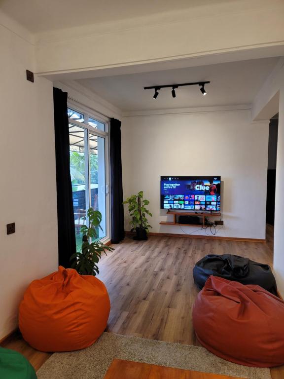 a living room with orange bean bags in front of a tv at Bunk 7 in Kandy