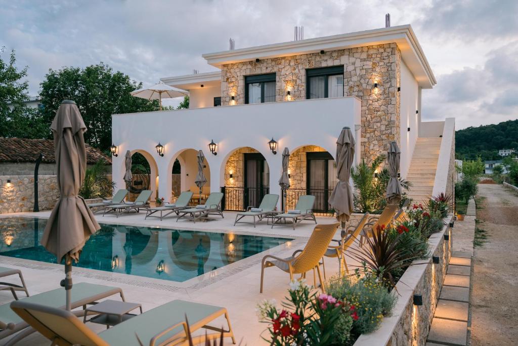 a villa with a swimming pool and chairs at B&B Lovac Pool & Spa in Ulcinj