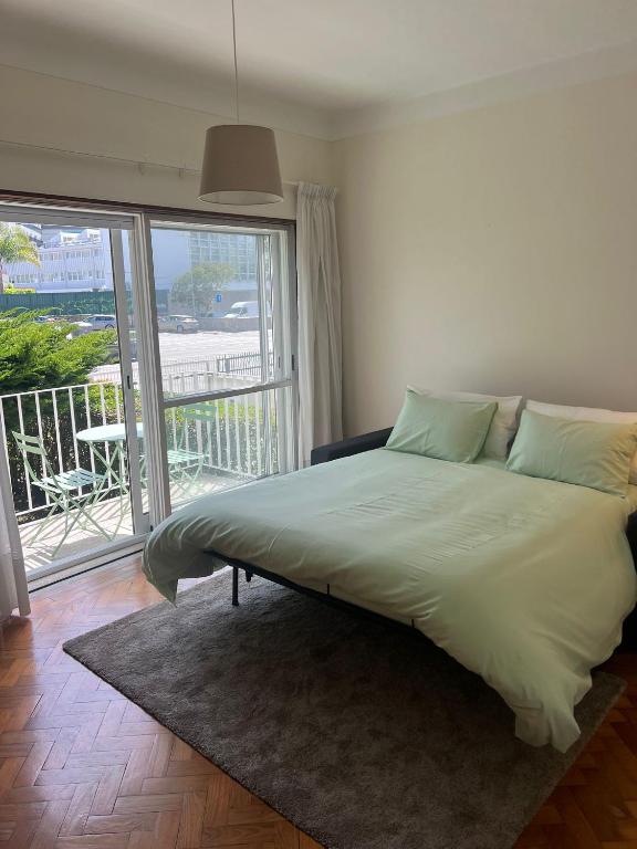 a large bed in a room with a balcony at City Centre Cozy Apartment in Porto