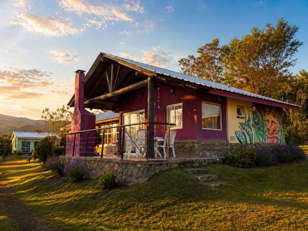 a small house on a hill with a sunset at El Zorro Cabin Nature and Relaxation near Salta in Salta