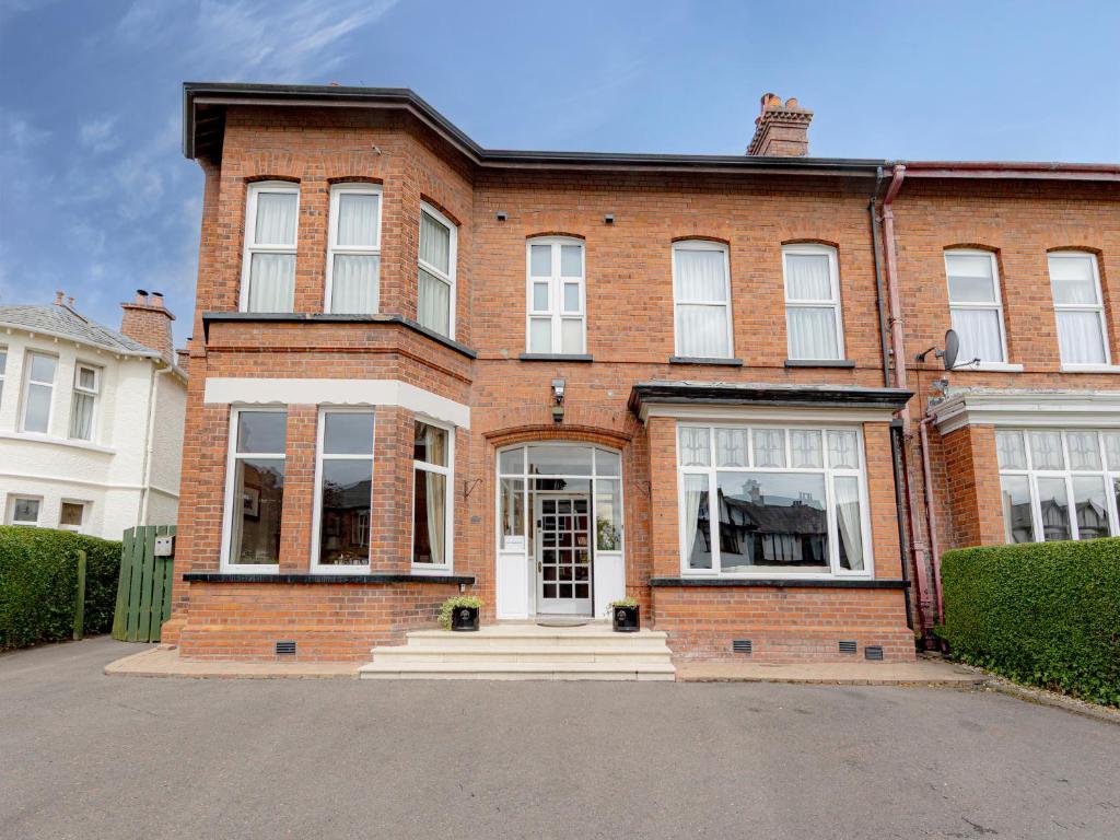 a red brick house with a white door at Somerton House Rooms Only in Belfast