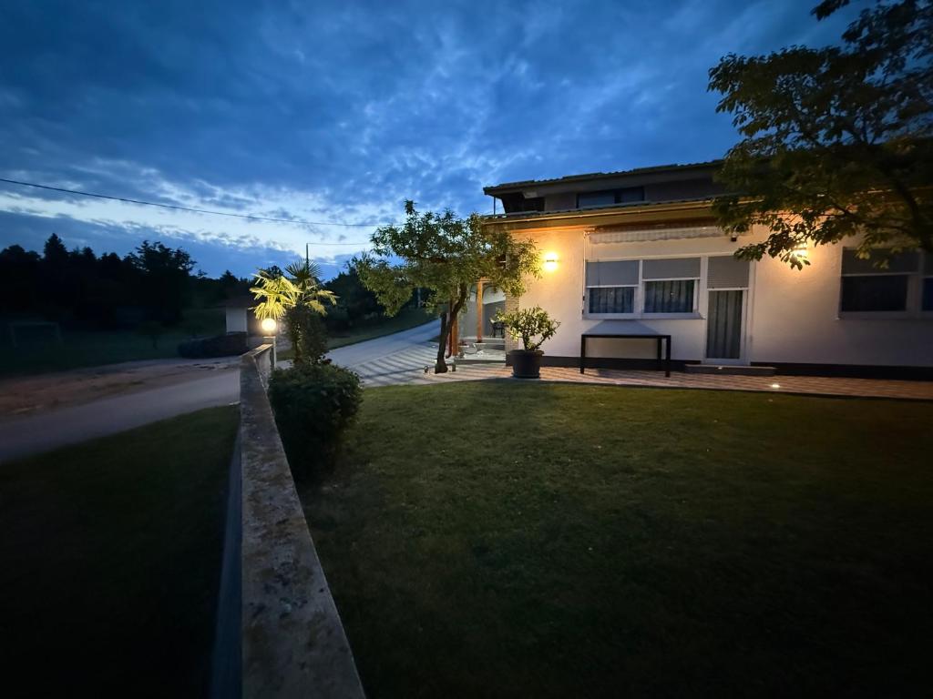 a house with a bench in front of a yard at Apartmani HeManoS in Duga Resa