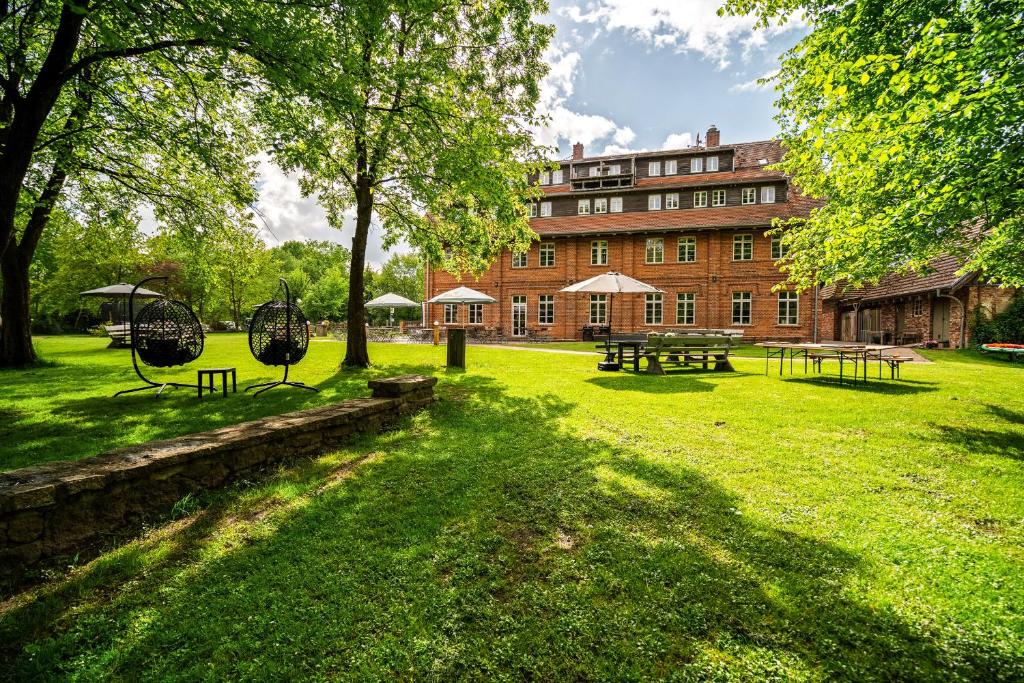 a park with benches and a large brick building at Hotel Bolter Mühle - DZ Mohnbuchte in Rechlin