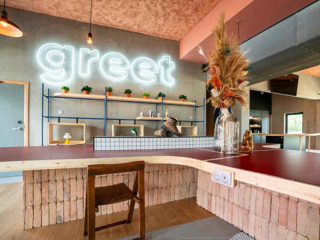 a restaurant with a counter with a sign that reads greed at greet hotel Cernay Mulhouse in Cernay
