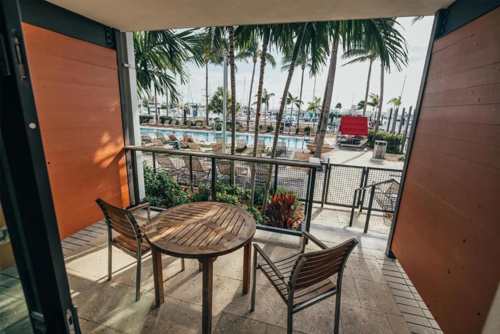 a balcony with a table and chairs and a pool at The Perry Hotel & Marina Key West in Key West