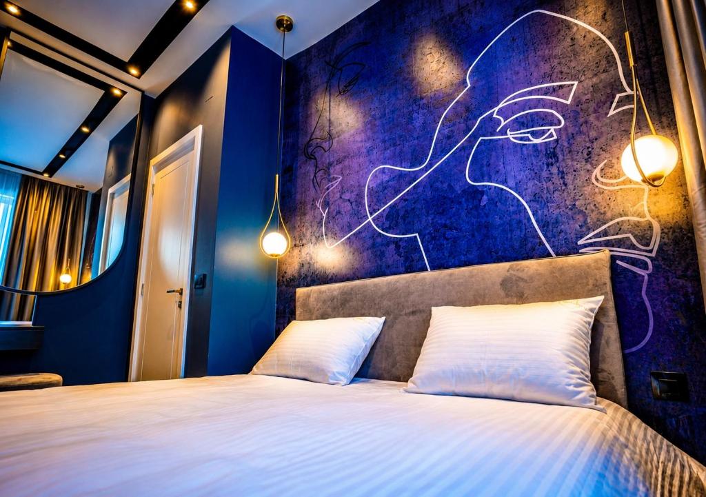 a bedroom with a bed with a purple wall at Miha Premium Apartment 2BR 50m from Main Square in Belgrade