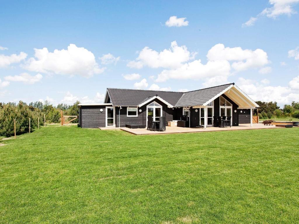 a black house with a large green lawn at Luxury Retreat with Spa - By Traum Ferienwohnungen in Bøtø By