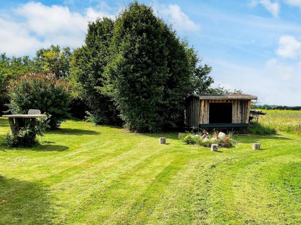 a garden with a bench and a shed in the grass at 4 star holiday home in Hornsyld in Hornsyld