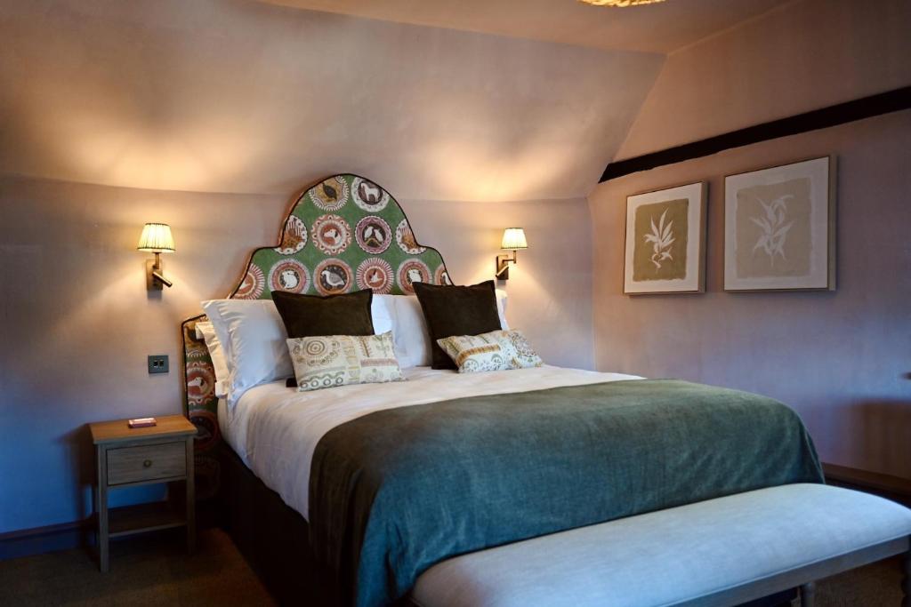 a bedroom with a large bed with a large headboard at Botley Hill Farmhouse in Warlingham