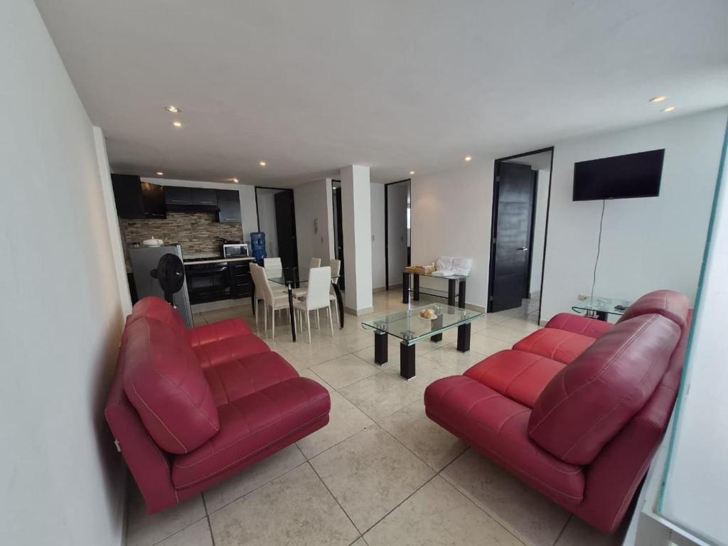 a living room with two red couches and a table at Modern apartment Altravia 6 tower in Cholula
