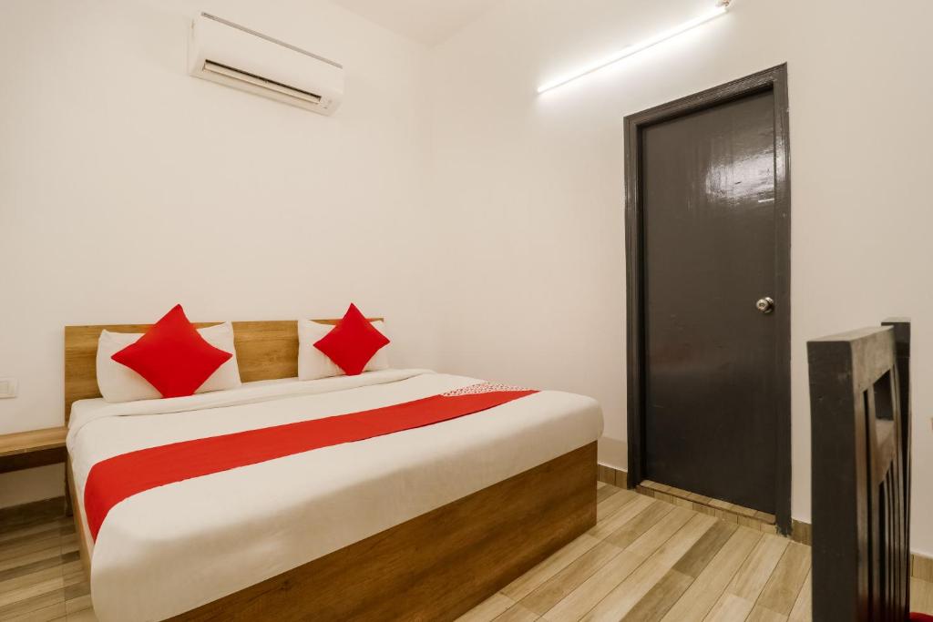 a bedroom with a large bed with red pillows at Hotel O Perky Stay in Faridabad