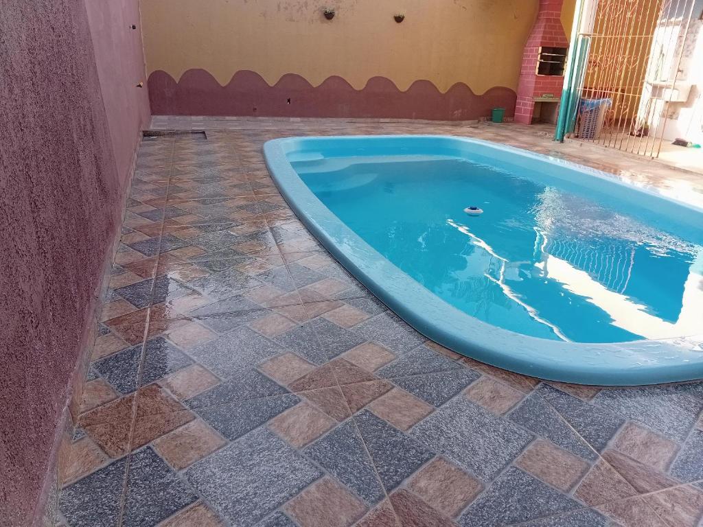 a swimming pool with a tiled floor and a blue tub at Refúgio familiar in Belém
