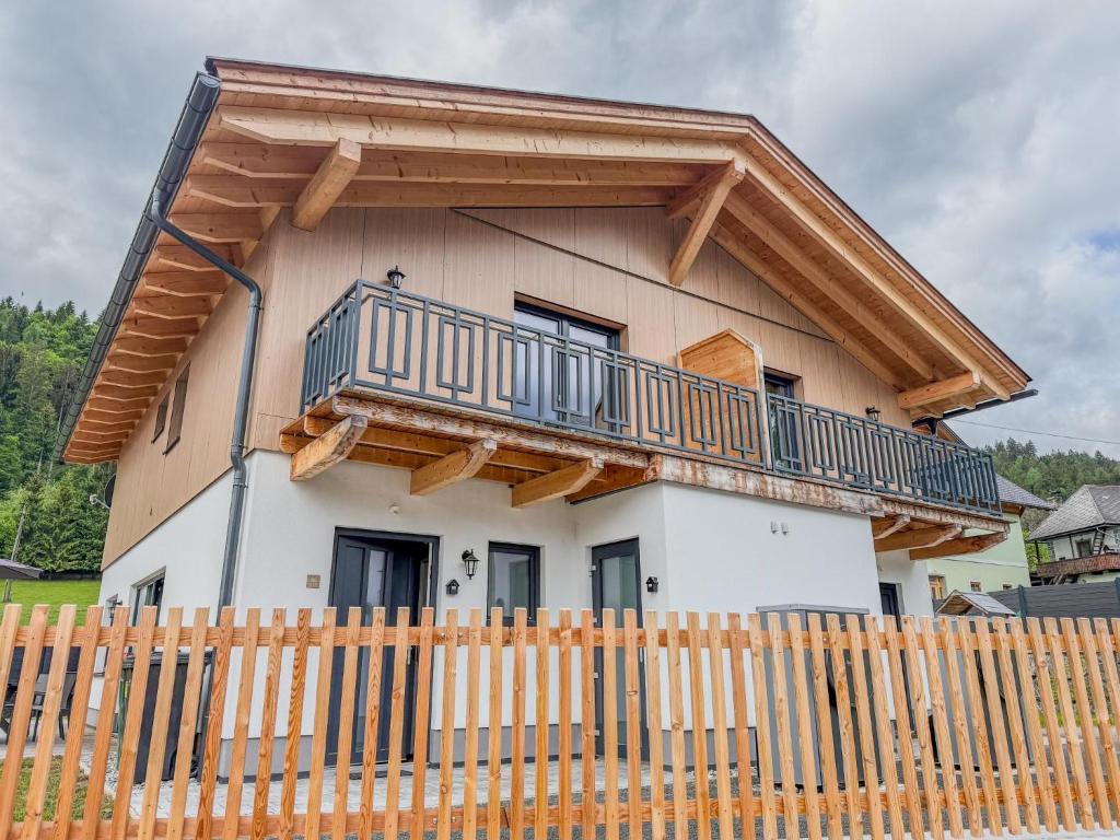 a house with a balcony and a wooden fence at Obermöschach 1B in Lake Pressegg