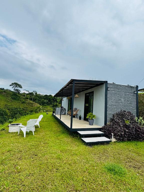 a small house with a deck and two benches at Kèbi Container Home near Blue Falls in Colonia