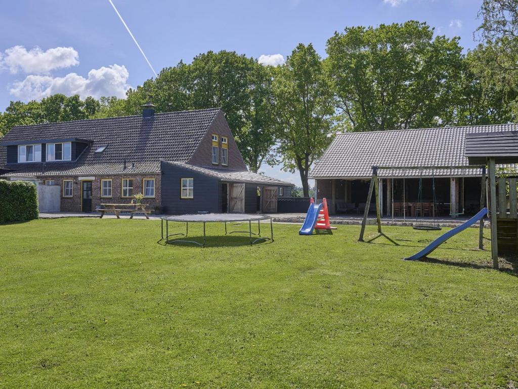 a yard with a playground with a table and swings at De open schuur in Elsendorp