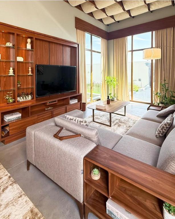 Orien chalet في Abū Nukhayl: غرفة معيشة بها أريكة وجهاز تلفزيون