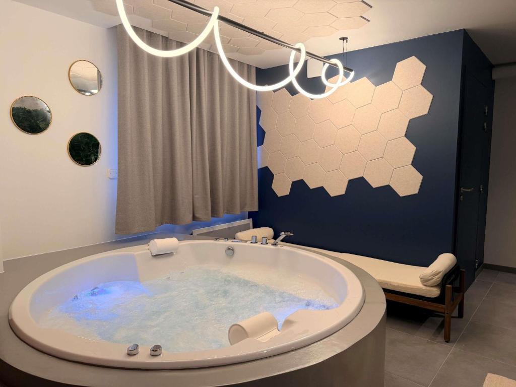 a jacuzzi tub in the middle of a bathroom at Greet Hotel Brest Aéroport in Guipavas