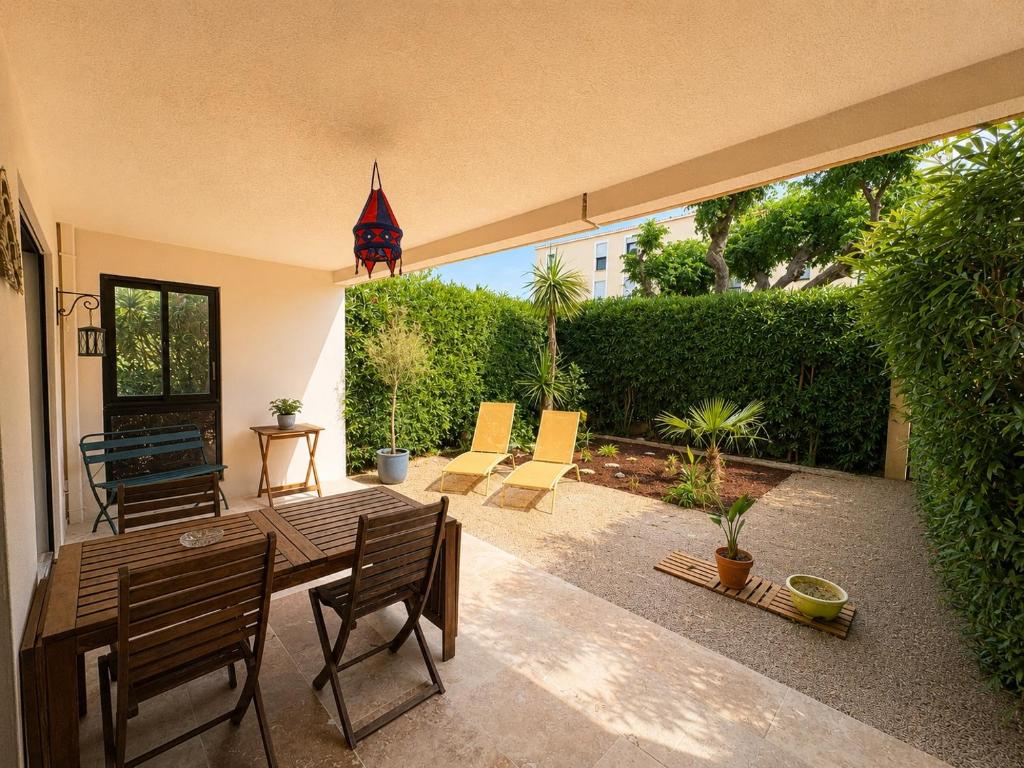 a patio with a wooden table and chairs at La cigale bleue - Garden level in Sanary-sur-Mer
