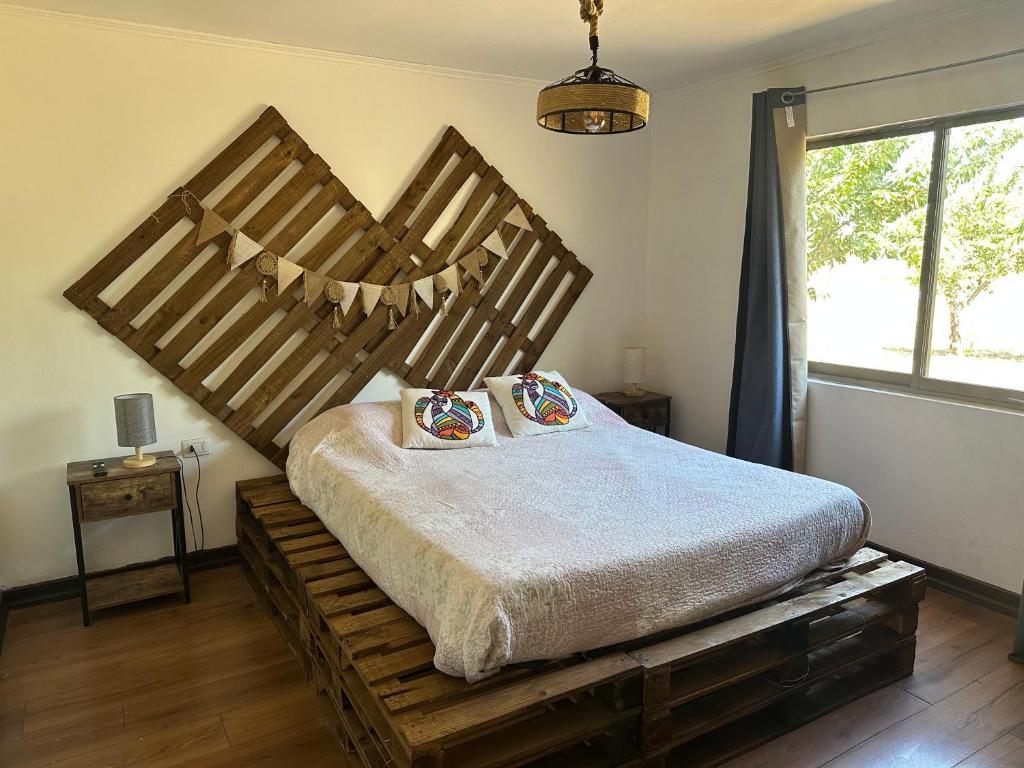 a bedroom with a large wooden bed with pillows on it at Quincho la Beli in Chillán