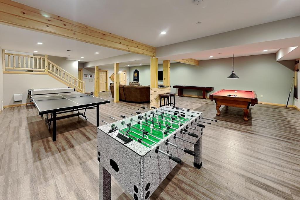 a room with two ping pong tables and a pool table at Off the Deep End in McHenry