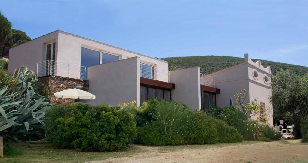 a large house with a hill in the background at Residenza Rosso Di Sera in Capoliveri